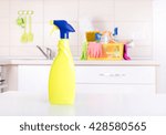 House cleaning concept. Close up of spray bottle on white table in front of kitchen cabinets