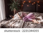 Small photo of Depressed middle-aged alone female curled up in fetal position lying in bed, concept of chronic insomnia, sleeping disorder, grieving about divorce or diagnosis disease, mental problems