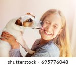Happy child with dog. Portrait girl with pet. Jack Russell licks a teen