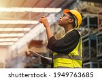 Black African professional women worker working count checking inventory production stock control in business factory  industry warehouse waring engineer suit and helmet for safety
