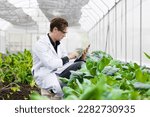 Small photo of Agriculture scientist man working plant research in bio farm laboratory. Biologist study collecting data with laptop computer.