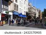 Small photo of EXETER, UK - AUGUST 22, 2023 - View along High Street shopping street with the Guildhall to the middle in the city centre, Exeter, Devon, UK, Europe, August 22, 2023.
