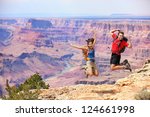 Happy people jumping in Grand Canyon. Young multiethnic couple on hiking travel. Grand Canyon, south rim, Arizona, USA.