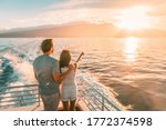 Cruise ship vacation travel tourists couple watching sunset on deck summer travel. lady pointing at sun to man tourist relaxing on Caribbean holidays.