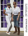 Small photo of Bisbee, Arizona, USA, April 6, 2015, Phylis Tampio and Leslie Plimpton pose in front of purple draped doorway