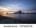 View of Detroit city skyline at sunset from the shore of the river on the canadian side