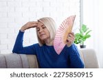 Small photo of Mature woman experiencing hot flush from menopause at home