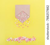 Small photo of Multicolor sweets sugar candy hearts pour forth of craft paper envelope on bright yellow background . Valentine day. love concept. Gift, message for lover. Space for text. Square card