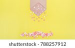 Small photo of Multicolor sweets sugar candy hearts pour forth of craft paper envelope on bright yellow background . Valentine day. love concept. Gift, message for lover. Space for text. Wide banner