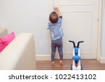 Small photo of Asian 18 months / 1 year old toddler baby boy standing on tiptoes at home, Kid reaching up try to open / close door knob, Child want to escape to play, explore outdoor, Security and Safety Concept
