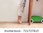 Small photo of Closeup photo of Asian 18 months / 1 year old toddler baby boy child standing on tiptoes floor at home, Kid reaching up for things on the table - Soft & Selective focus
