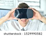 Young Businessman Wearing Virtual Reality Googles. Looking Around On Stock Chart And Report. Close Up