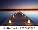wooden jetty with burning candles, romantic place at the beach 