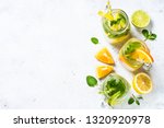Lemonade set. Lemonade, mojito and orange lemonade. Iced summer drink in mason jar with ingredients on white table top view.