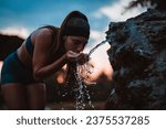 Small photo of Active Woman Refreshes with Water After Strenuous Training in Beautiful Park