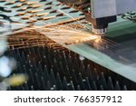 The fiber  laser cutting machine  cutting the sheet metal plate with the sparking light.Hi-technology manufacturing concept.