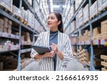 asian female business owner using digital tablet checking amount of stock product inventory on shelf at distribution warehouse factory.logistic business shipping and delivery logistic service