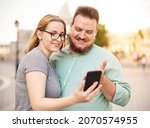smiling young couple using... | Shutterstock . vector #2070574955