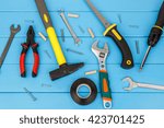 Small photo of View of straggly work tools laying on blue wooden background.