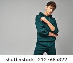Small photo of Handsome man wear of green set of track suit isolated on grayl background